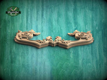 Load image into Gallery viewer, two ornate wooden carvings with intricate designs, displayed against a green textured background.