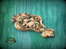 Load image into Gallery viewer, A wooden carving with intricate scrollwork is displayed against a green background.