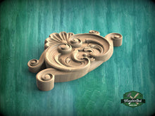 Load image into Gallery viewer, A wooden carving with intricate scrollwork is displayed against a green background.
