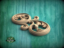 Load image into Gallery viewer, A decorative wooden carving in the shape of a swirl or scroll is displayed against a teal-colored background.