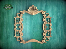Load image into Gallery viewer, an ornate, carved wooden frame with intricate scrollwork and a shell-like design at the top, set against a teal background.