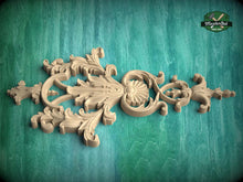 Load image into Gallery viewer, A decorative wooden carving with intricate floral and scrollwork designs is displayed against a green background.
