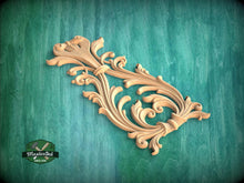 Load image into Gallery viewer, an ornate, carved wooden piece with intricate scrollwork and floral designs, set against a green background.