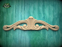 Load image into Gallery viewer, a decorative wooden carving on a green wooden surface.