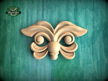 Load image into Gallery viewer, A wooden carving of a butterfly-like design is displayed against a green background.