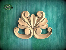 Load image into Gallery viewer, A wooden carving of a stylized flower or leaf design is displayed against a teal background.