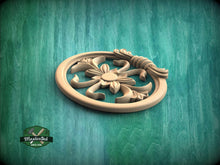 Load image into Gallery viewer, A wooden ornamental piece with a floral design, placed on a green textured background.
