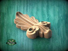 Load image into Gallery viewer, A wooden carving of a stylized leaf or flower-like shape is displayed against a green background.