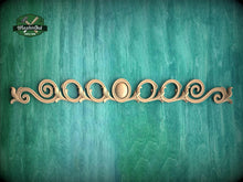 Load image into Gallery viewer, a decorative wooden piece with a floral design, placed against a green background.