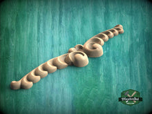 Load image into Gallery viewer, A wooden carving with a curved, ornate design is displayed against a green background.
