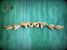 Load image into Gallery viewer, a wood carving of leaves and flowers on a green background