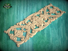 Load image into Gallery viewer, an ornate, carved wooden panel with intricate floral and scroll designs, set against a green background.