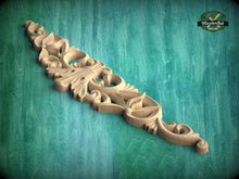 Load image into Gallery viewer, A decorative wooden carving with intricate floral and scrollwork designs is displayed against a green textured background.