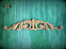 Load image into Gallery viewer, A decorative wooden carving with an ornate, floral-inspired design is displayed against a teal-colored background.