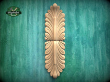 Load image into Gallery viewer, a decorative wooden carving on a green background.