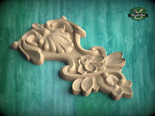 Load image into Gallery viewer, A wooden carving with intricate floral and leaf designs is displayed against a green background.