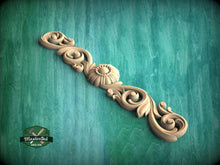Load image into Gallery viewer, a wood carving of a decorative design on a green background