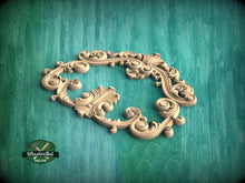 Load image into Gallery viewer, A decorative wooden frame with intricate scrollwork and floral patterns is displayed against a teal background.