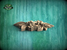 Load image into Gallery viewer, A wooden carving of a flower-like shape is displayed against a teal-colored background.