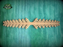 Load image into Gallery viewer, A decorative wooden leaf-like design is displayed on a green textured background.