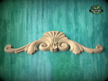 Load image into Gallery viewer, A decorative wooden carving with an intricate design is displayed against a teal-colored background.
