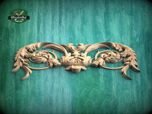Load image into Gallery viewer, A decorative wooden carving with intricate floral and leaf-like patterns is displayed against a green wooden background.