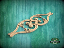 Load image into Gallery viewer, A decorative wooden carving with intricate scrollwork is displayed against a green background.