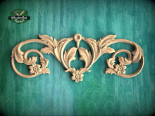Load image into Gallery viewer, a decorative wooden carving with intricate floral and scroll designs, set against a green background.