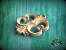 Load image into Gallery viewer, A wooden carving with an intricate, decorative design sits on a green textured background.
