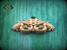Load image into Gallery viewer, A decorative wooden carving with intricate scrollwork is displayed against a green textured background.