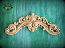 Load image into Gallery viewer, an ornate, carved wooden design with intricate scrollwork and floral elements, set against a green background.