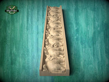 Load image into Gallery viewer, A wooden carving of a series of animals, likely horses, arranged in a vertical line on a wooden surface.
