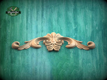 Load image into Gallery viewer, a wooden carving of a flower on a green background