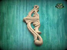 Load image into Gallery viewer, A decorative wooden carving or mold is displayed against a green textured background.