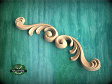 Load image into Gallery viewer, a wood carving of a swirl on a green background