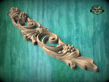 Load image into Gallery viewer, A decorative wooden carving with intricate floral and scrollwork designs is displayed against a teal background.