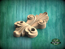 Load image into Gallery viewer, A wooden carving of a leaf-like design is displayed against a green background.