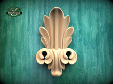 Load image into Gallery viewer, a decorative wooden sculpture with an intricate, ornate design on a green textured background.