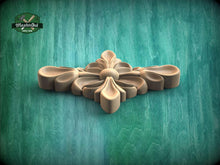Load image into Gallery viewer, A wooden carving of a flower-like design is displayed against a green background.