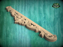 Load image into Gallery viewer, A decorative wooden carving with intricate floral and scrollwork designs is displayed against a green background.
