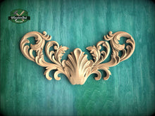 Load image into Gallery viewer, an ornate, carved wooden design with intricate scrollwork and floral elements, set against a green background.