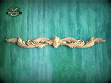 Load image into Gallery viewer, a wood carving of a flower on a green background