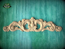 Load image into Gallery viewer, a decorative wooden carving on a teal background.