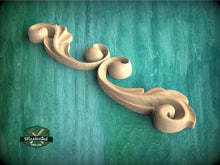 Load image into Gallery viewer, a wood carving of a decorative design on a green background
