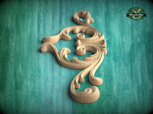 Load image into Gallery viewer, A decorative wooden carving in the shape of a swirly design is displayed against a teal background.