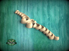 Load image into Gallery viewer, A decorative wooden carving in the shape of a flower or leaf, with a textured green background.