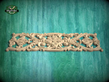 Load image into Gallery viewer, a decorative wooden carving on a green background.