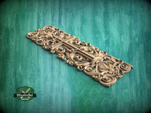 Load image into Gallery viewer, an ornate, carved wooden panel with intricate designs and patterns, set against a green background.