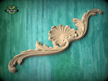 Load image into Gallery viewer, A decorative wooden carving with a shell-like design is displayed against a teal background.
