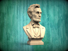 Load image into Gallery viewer, A bust of Abraham Lincoln, a famous American president, is displayed against a green wooden background.
